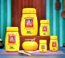 A butter jar and two tasty cv ghee cans are among the dairy items on display on a wooden platform.